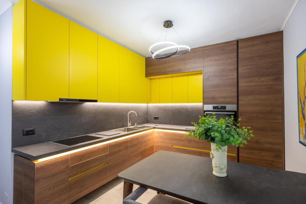 cocina con armarios amarillos y mesa en The view2-‘FREE PARKING’, en Sarandë