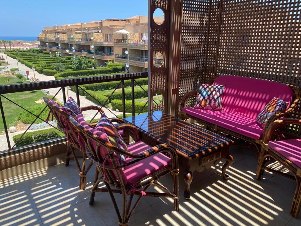 een veranda met stoelen en een bank op een balkon bij Blumar North Coast in El Alamein