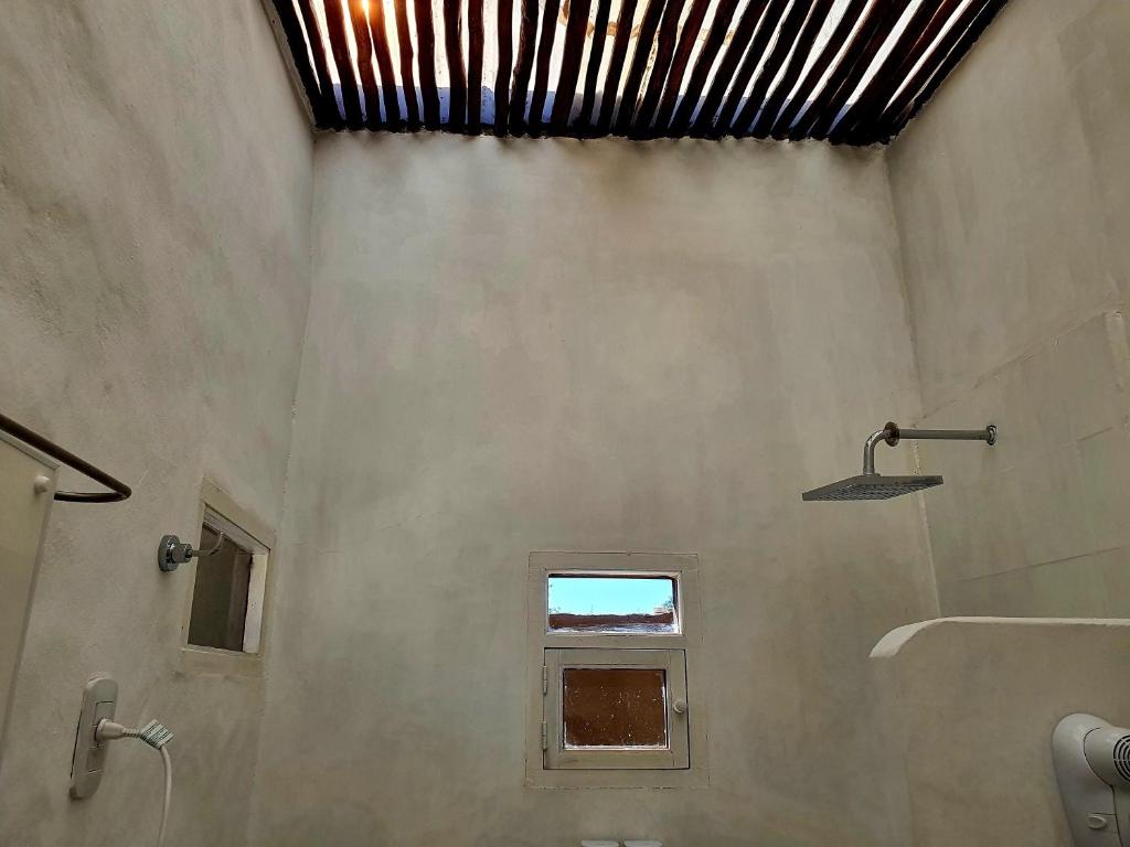 a bathroom with a shower and a window at Los tarcos Guest House TILCARA LOFT in Tilcara