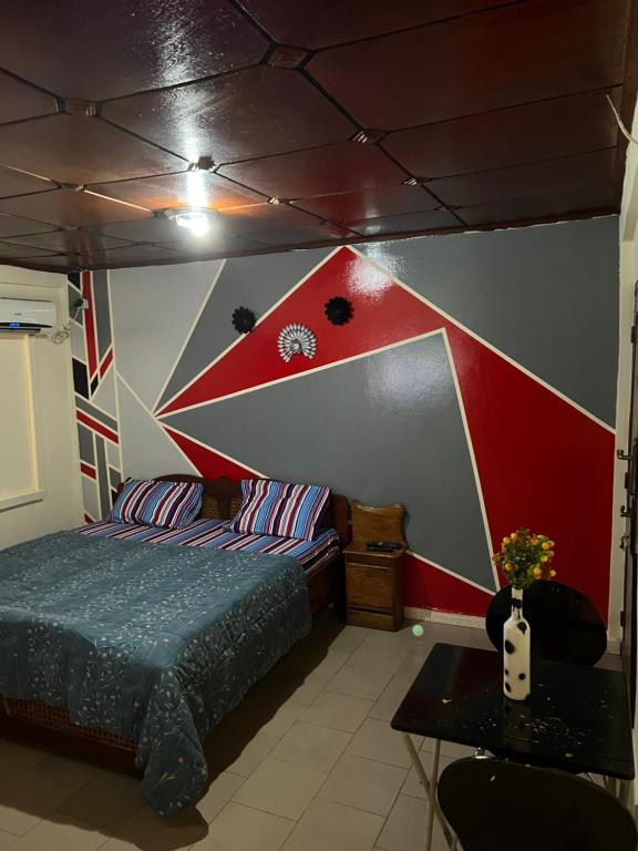 a bedroom with a bed and a red and white wall at Studio meublé à Conakry in Conakry