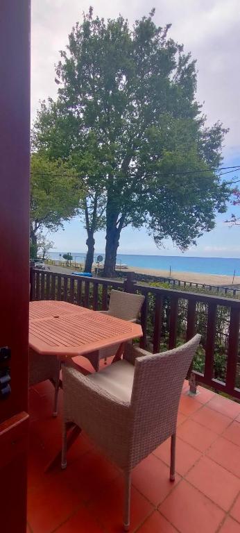 a wooden table and chairs on a balcony with the beach at Vintage House by the Sea in Chorefto