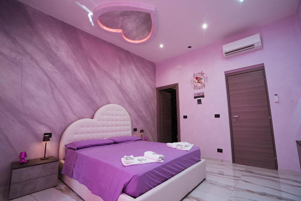 a pink bedroom with a bed with a heart shaped headboard at Lovely homes in Genova