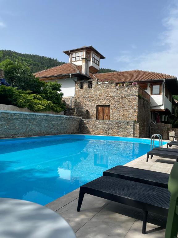 a swimming pool in front of a house at Heritage home Ustikolina in Foča
