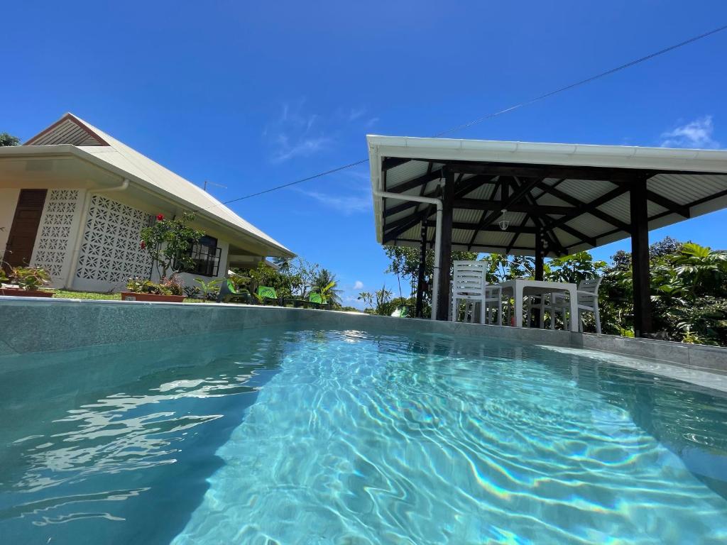 a swimming pool in front of a house at Villa Ura in Uturoa