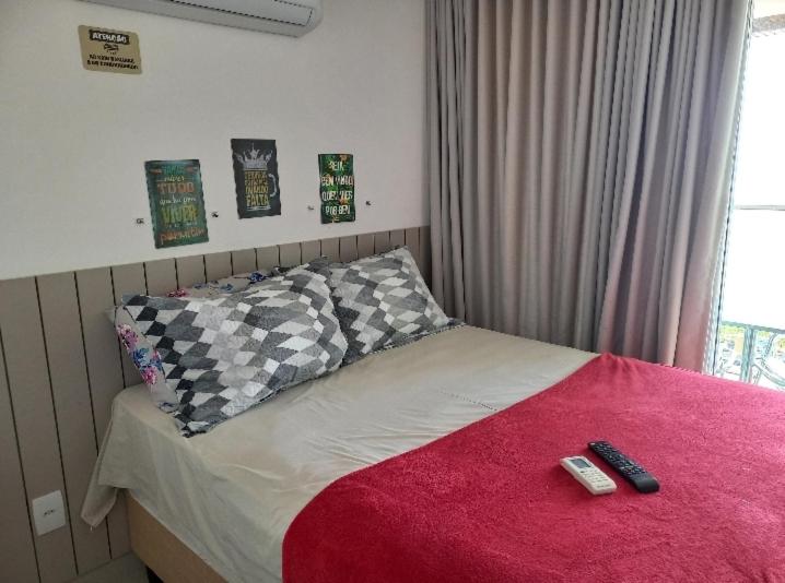 a bed with two remote controls on top of it at Flat maravilhosa vista beira mar de Intermares 605 in Cabedelo
