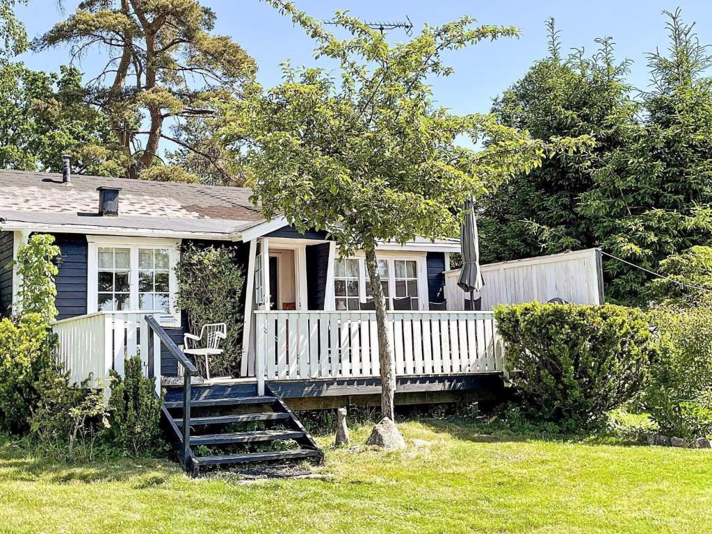 a small blue house with a porch and a tree at 2 person holiday home in APLARED-By Traum in Svaneholm