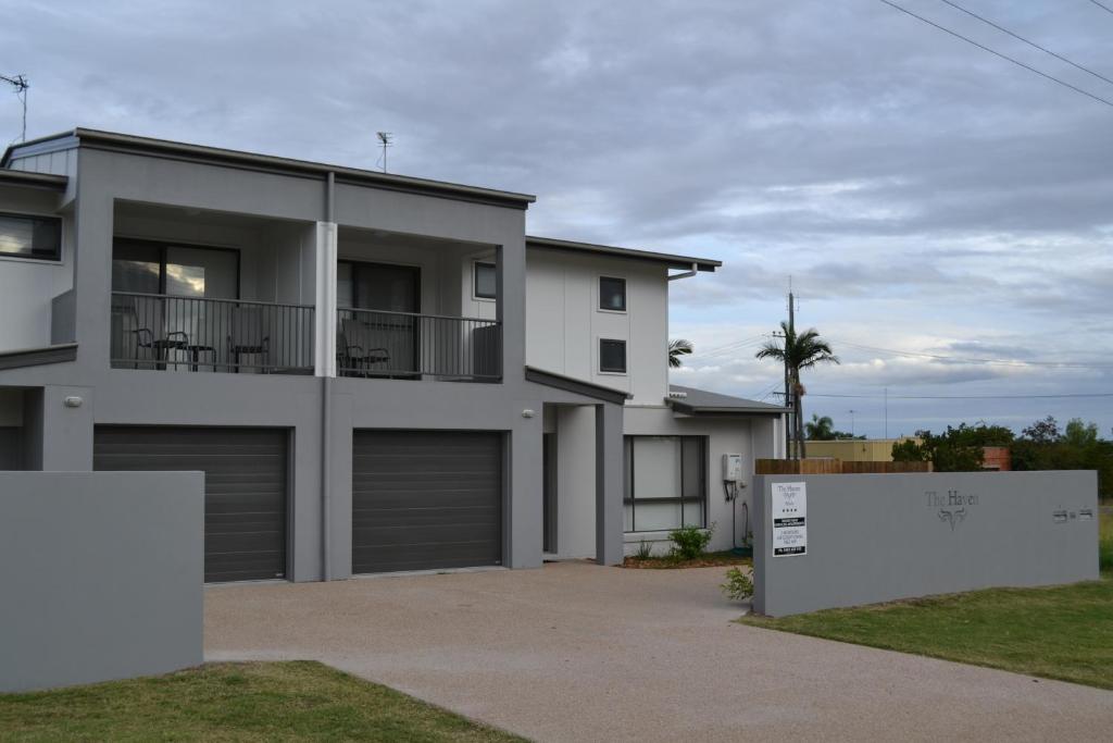 a large white house with two garage doors at The Haven Biloela in Biloela