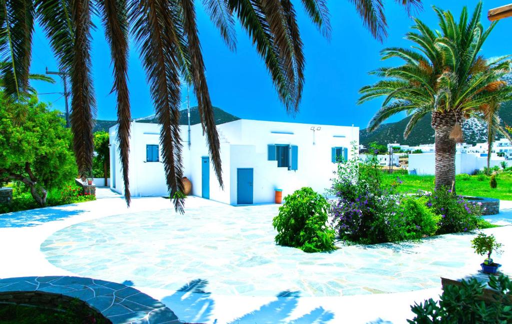 a courtyard with palm trees and a white house at ANCIENT MEROPIA - Astrogonio, Apollonia in Apollonia