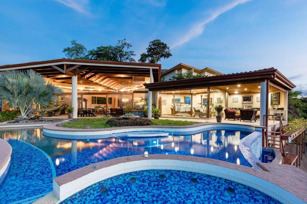 una casa con piscina frente a una casa en Villa Dos Playas, en Playa Hermosa