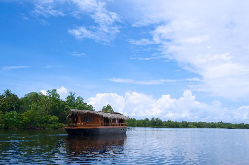a boat sitting in the middle of a lake at Yathra Houseboat in Bentota