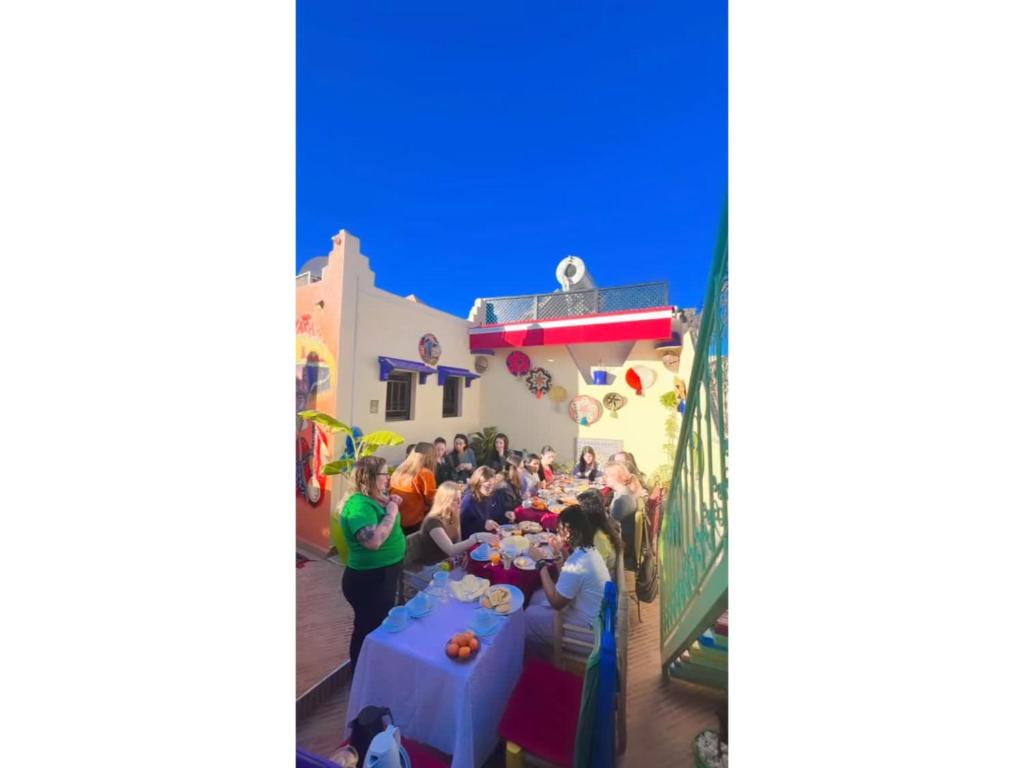 um grupo de pessoas em pé em torno de uma mesa em uma festa em Riad Eva em Marrakech