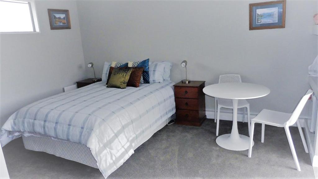 a bedroom with a bed and a table and chair at Deb's Place in Swannanoa