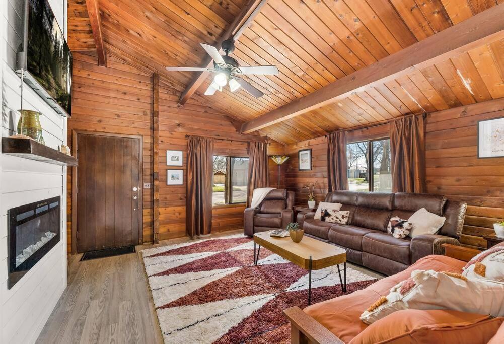 een woonkamer met een bank en een plafondventilator bij Cozy Copper Cabin in the City in Sioux Falls