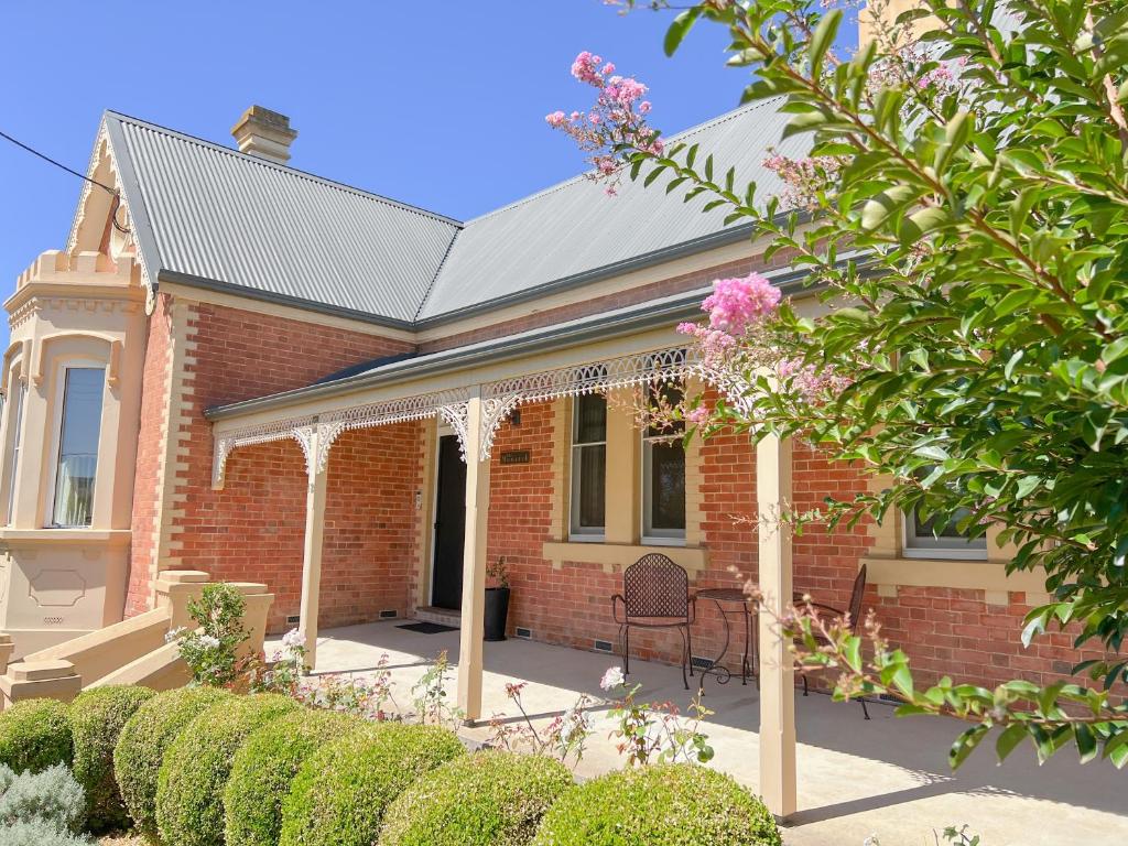 a brick house with a chair in front of it at The Monarch Tumut - Luxury in the valley in Tumut