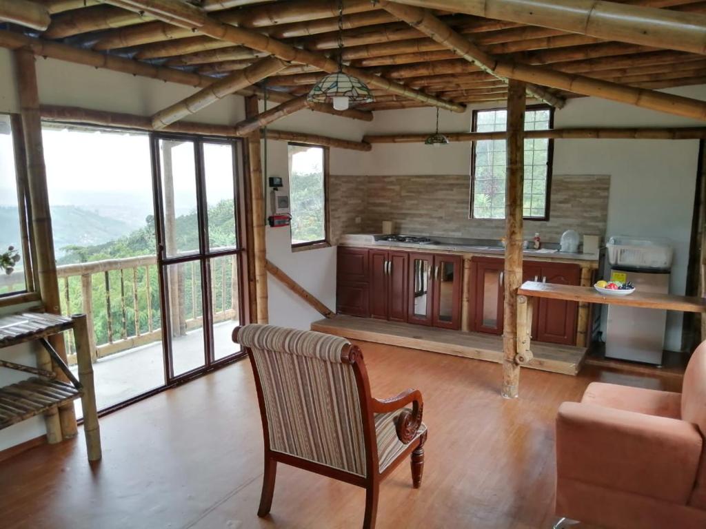 a living room with a table and a couch and some windows at Cabaña el Ensueño (GUADUA, BAMBU) in Pereira