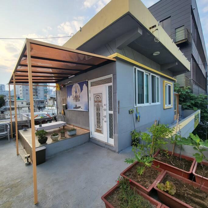 una pequeña casa azul con un patio con plantas en JUN house - Foreign Only, en Busan