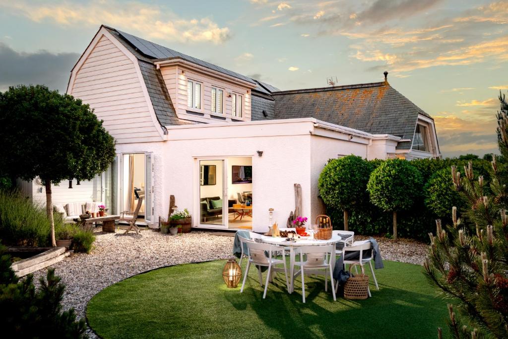 a white house with a table and chairs in the yard at The Studio in Pevensey