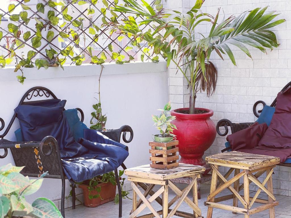 patio z 2 krzesłami i doniczką w obiekcie Villa soleil du Sénégal w mieście Dakar