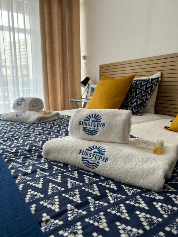 uma pilha de toalhas sentadas em cima de uma cama em SUNSTUDIO TARIK AL em Portimão