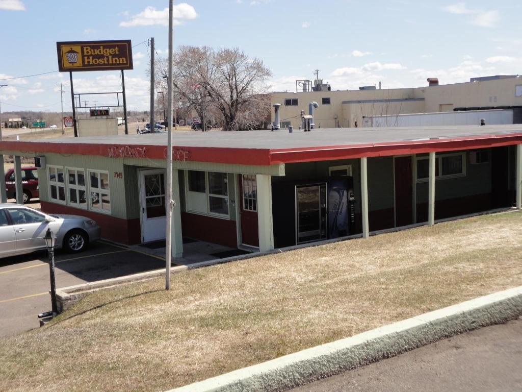 un edificio rojo y blanco con un coche aparcado delante en Budget Inn And Suites Eagan, en Eagan