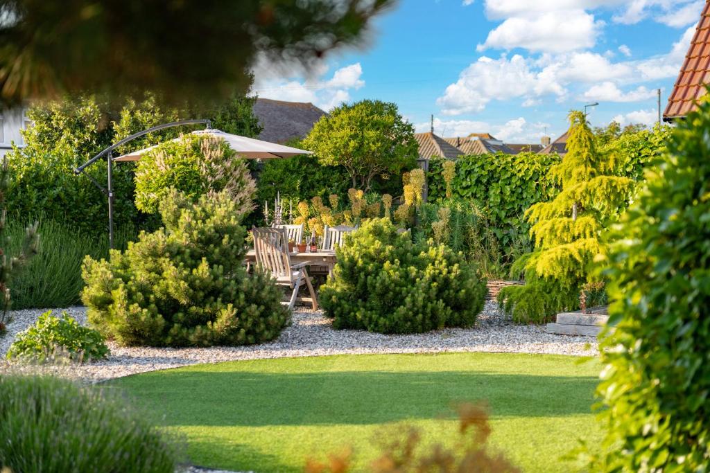 a garden with a table and chairs and trees at The Studio in Pevensey