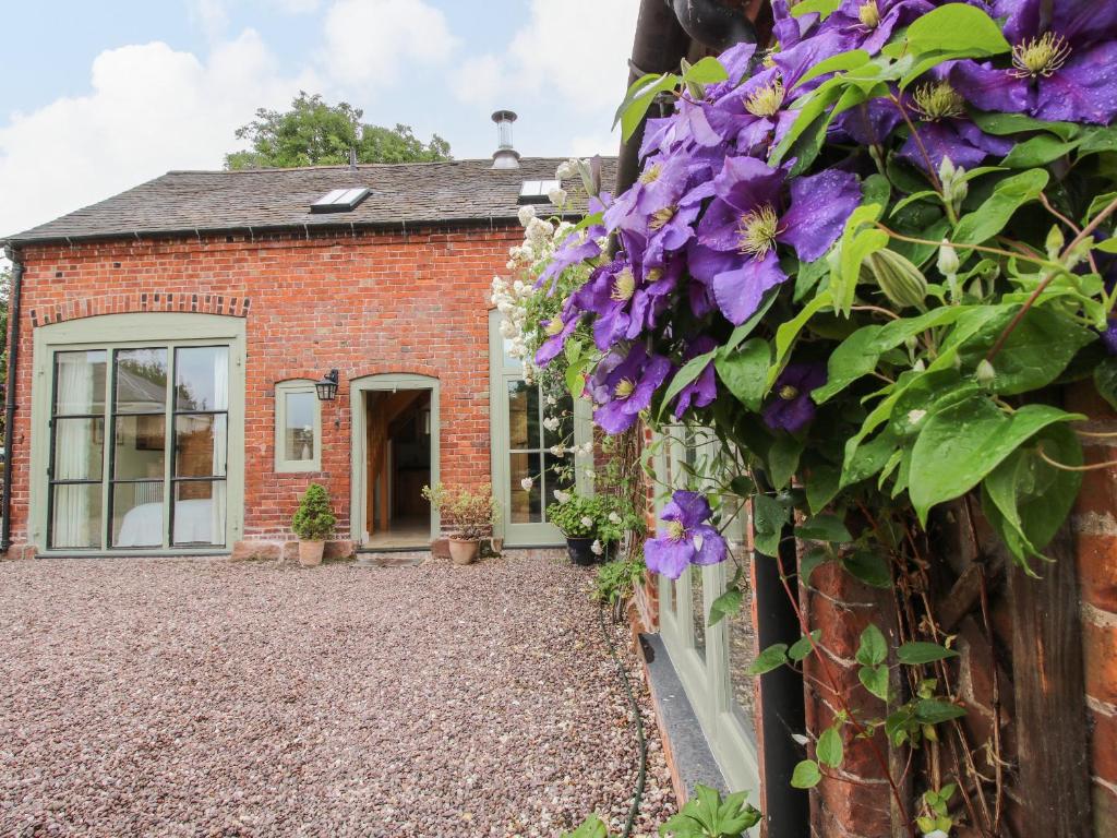 een huis met paarse bloemen erop bij Old Coach House in Shrawardine