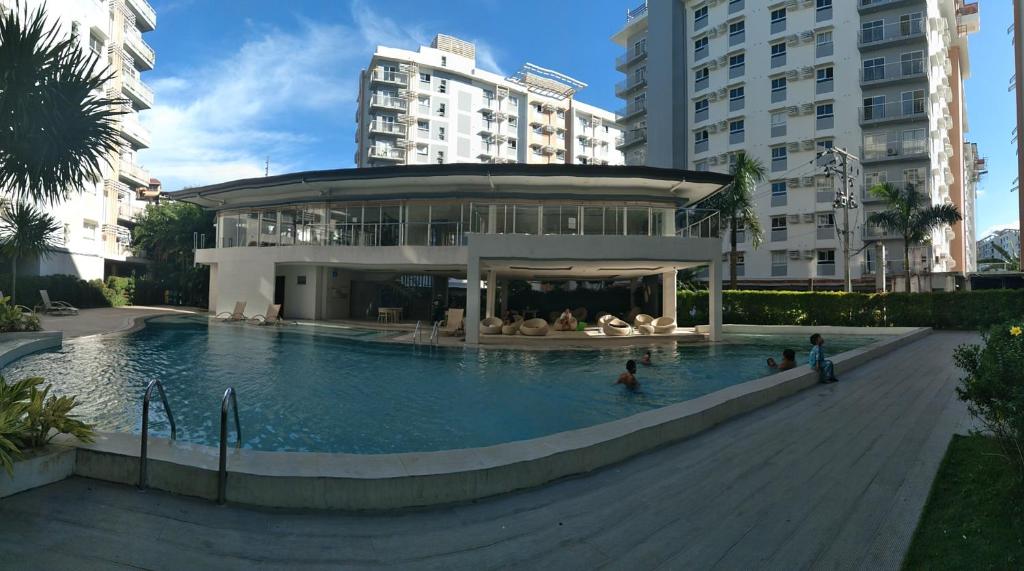 un bâtiment avec une piscine en face d'un bâtiment dans l'établissement Budget Room, à Cebu