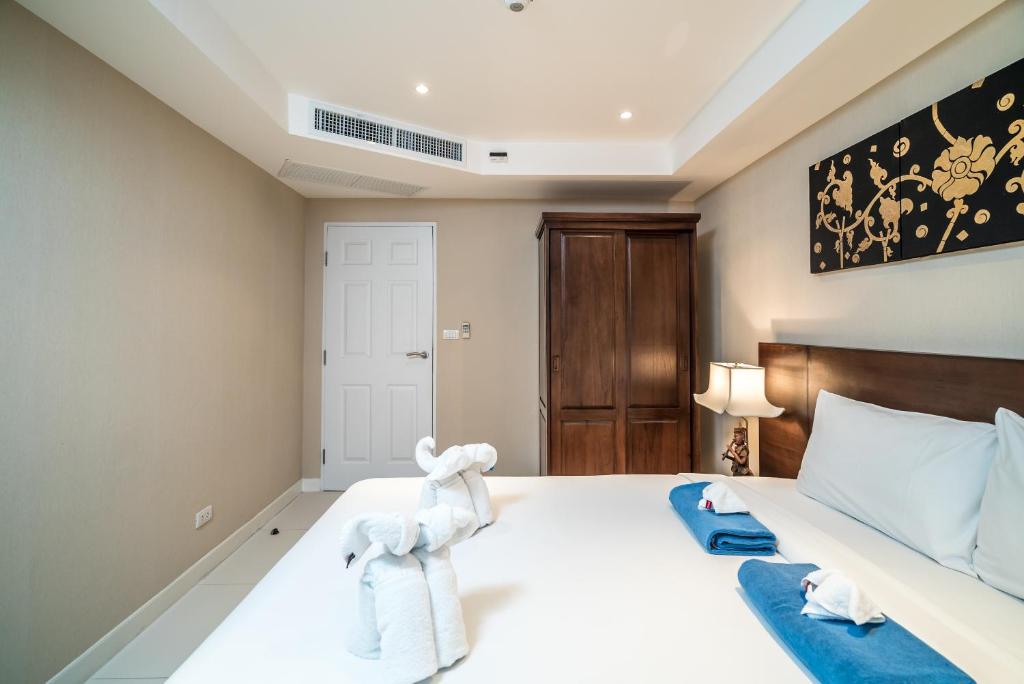a bedroom with a large white bed with towels on it at Kata Ocean View condominium by Lofty in Kata Beach