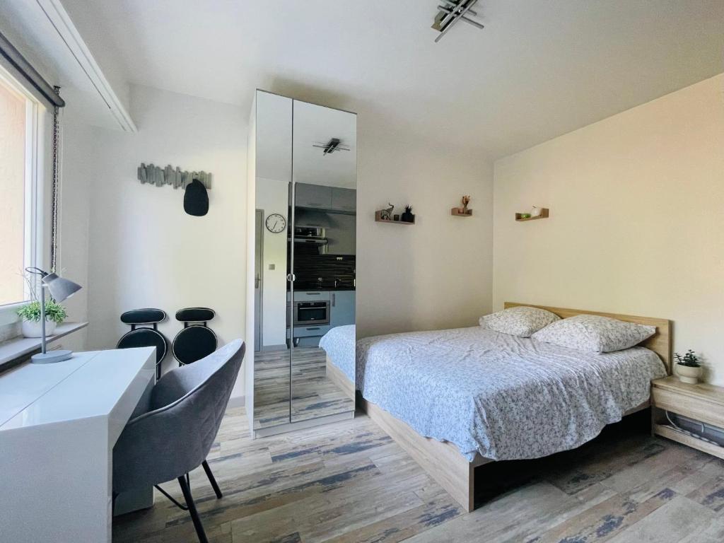 une chambre avec un lit, un bureau et un miroir dans l'établissement DnN - Stylish Studio - free WiFi, Netflix and parking - min away to Basel and Airport - dishwasher, washing machine, à Saint-Louis
