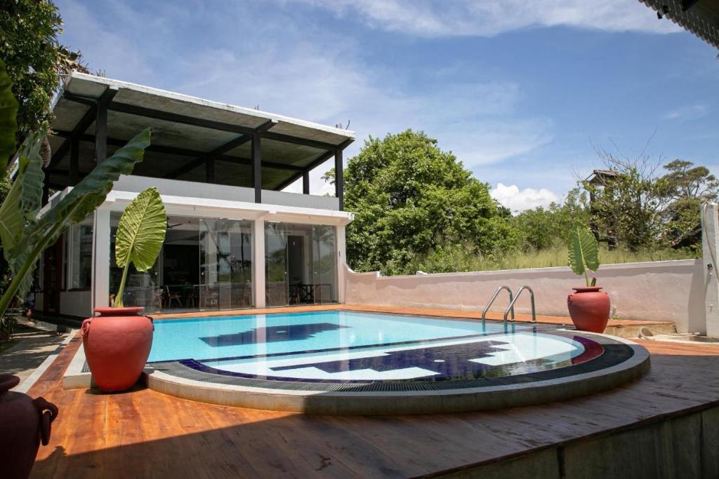 a swimming pool on a deck with a house at Aquamarine Weligama in Weligama