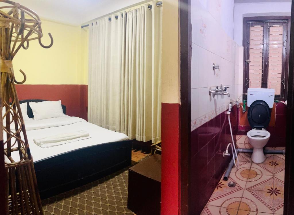 Cette petite chambre comprend un lit et des toilettes. dans l'établissement Thamel Hub Hostel, à Katmandou