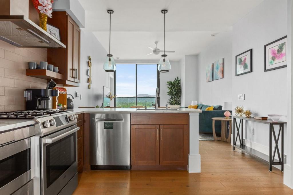 a kitchen with a sink and a stove top oven at 'Mountain Gem' A Luxury Downtown Condo with Mountain and City Views at Arras Vacation Rentals in Asheville