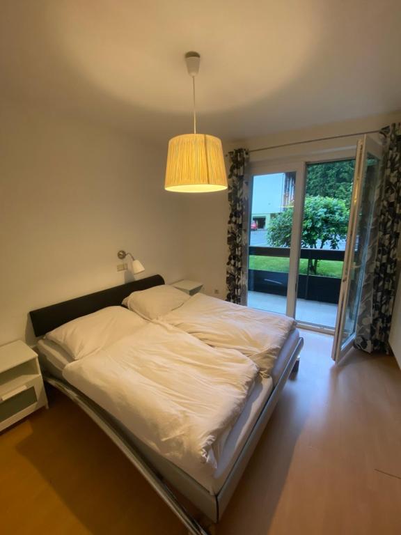 a bedroom with a bed with a lamp and a window at NOCK - Zentrum Studio in Bad Kleinkirchheim