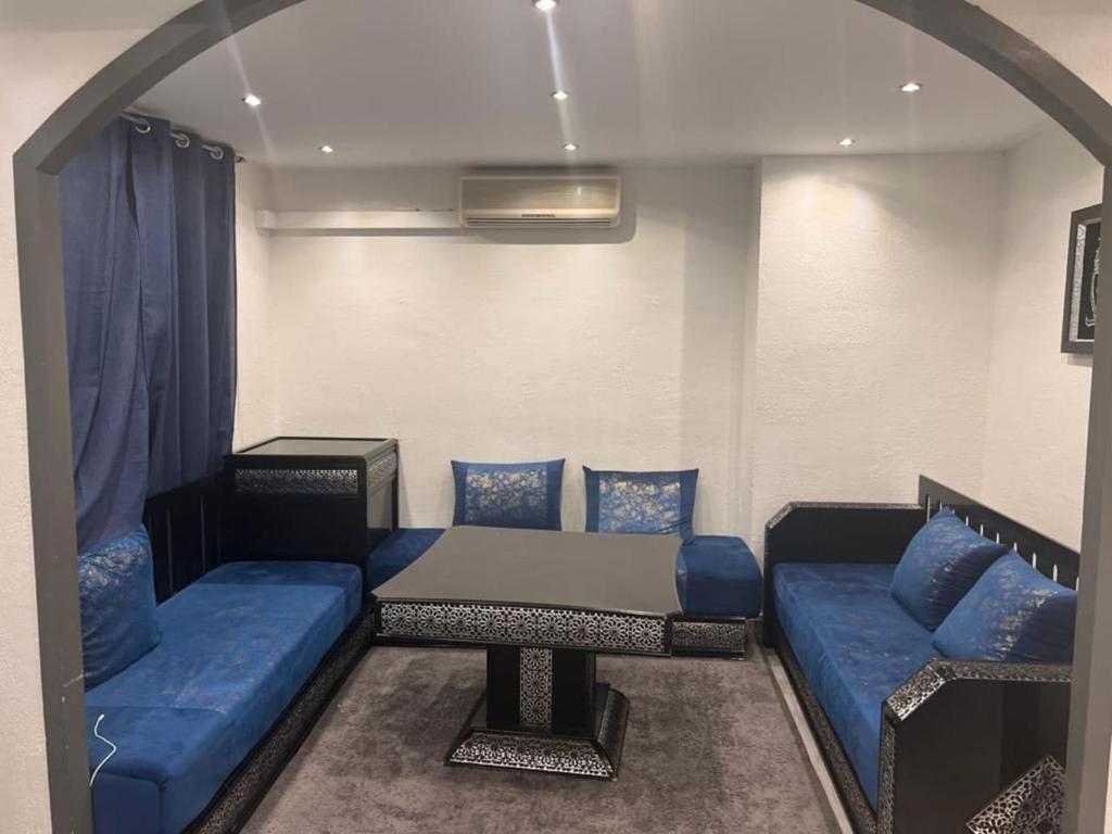 Habitación con sofá azul y mesa. en appartement ABI, en La Seyne-sur-Mer