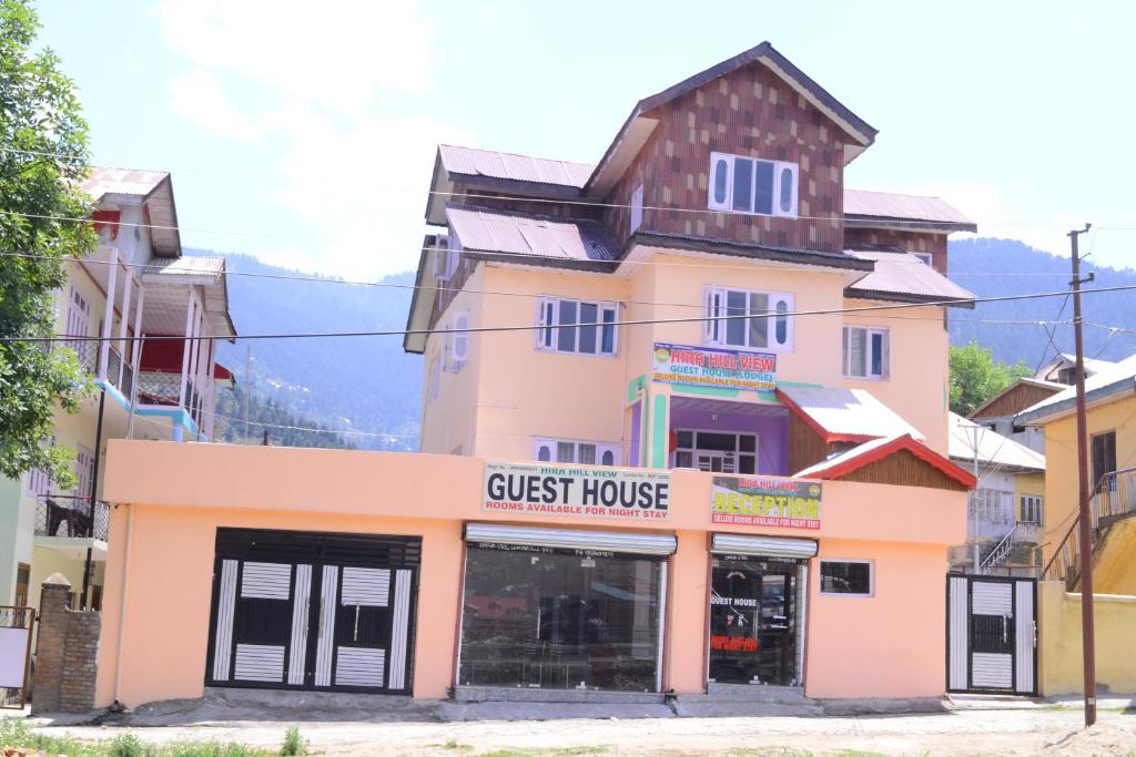 un bâtiment rose avec une maison d'hôtes dans l'établissement Hill View Guest House Bhaderwah, à Bhadarwāh