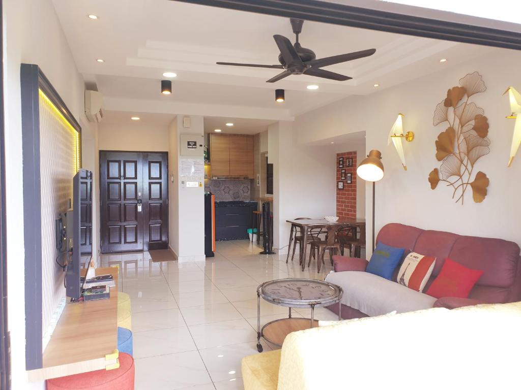 سري سايانغ باي كورال هوليداي ريزورت في باتو فيرينغي: غرفة معيشة مع أريكة ومروحة سقف