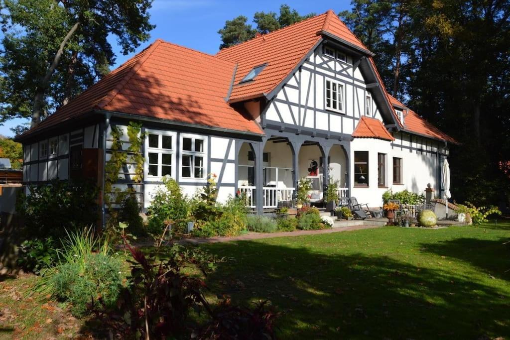 a white house with an orange roof at Große Ferienwohnung im Landhaus Labes (Stechlinsee) in Neuglobsow