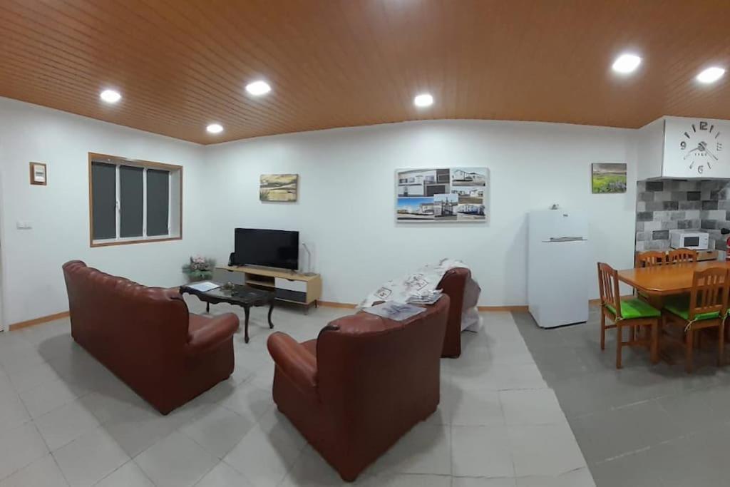 a living room with chairs and a table and a television at Cantinho do Cruzeiro Lajes in Lajes