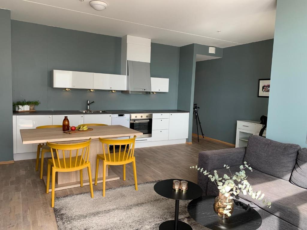 a kitchen and living room with a table and chairs at Svolvær Havn Apartments in Svolvær