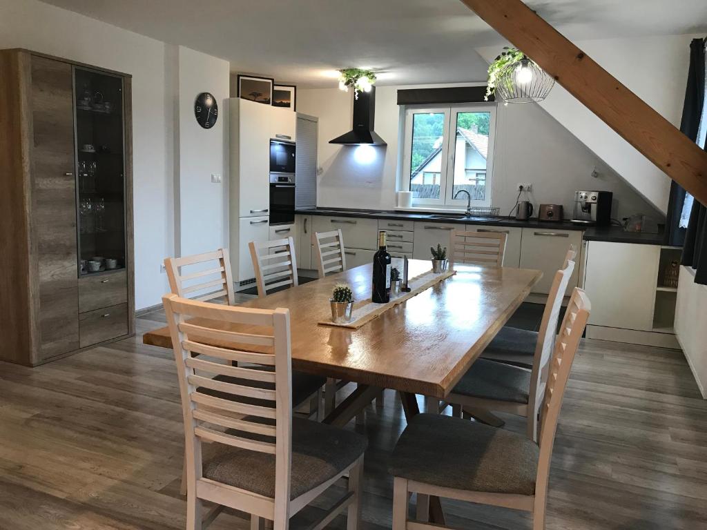 a kitchen and dining room with a wooden table and chairs at Riverside Habovka in Habovka