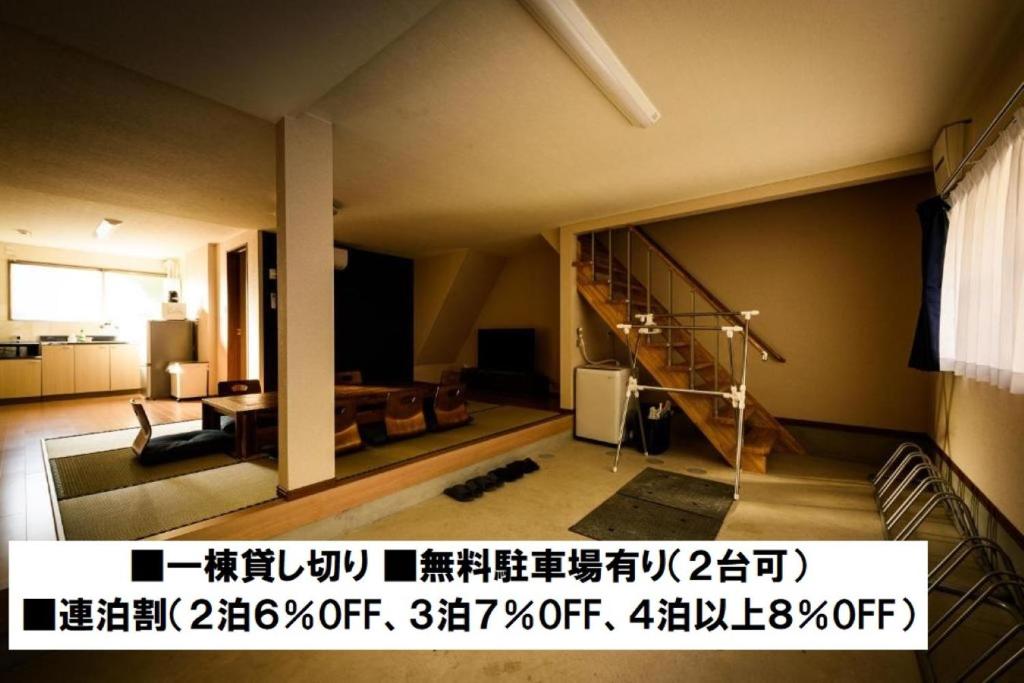 ein Wohnzimmer mit einer Treppe und einem Wohnzimmer in der Unterkunft Biker's Inn Onomichi 自転車の宿おのみち in Onomichi