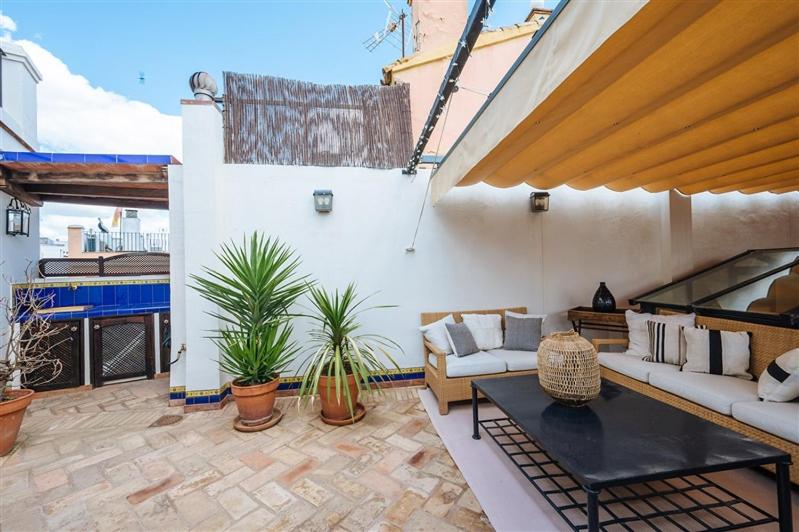 patio z kanapami i doniczkami na budynku w obiekcie CASA PALACIO SXVIII CON PISCINA en centro histórico de SEVILLA w Sewilli