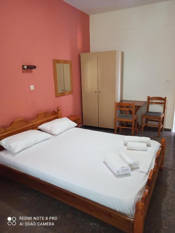 um quarto com 2 camas, uma mesa e uma cadeira em Ραπτη Θεοδωρα em Paralia Vrachou