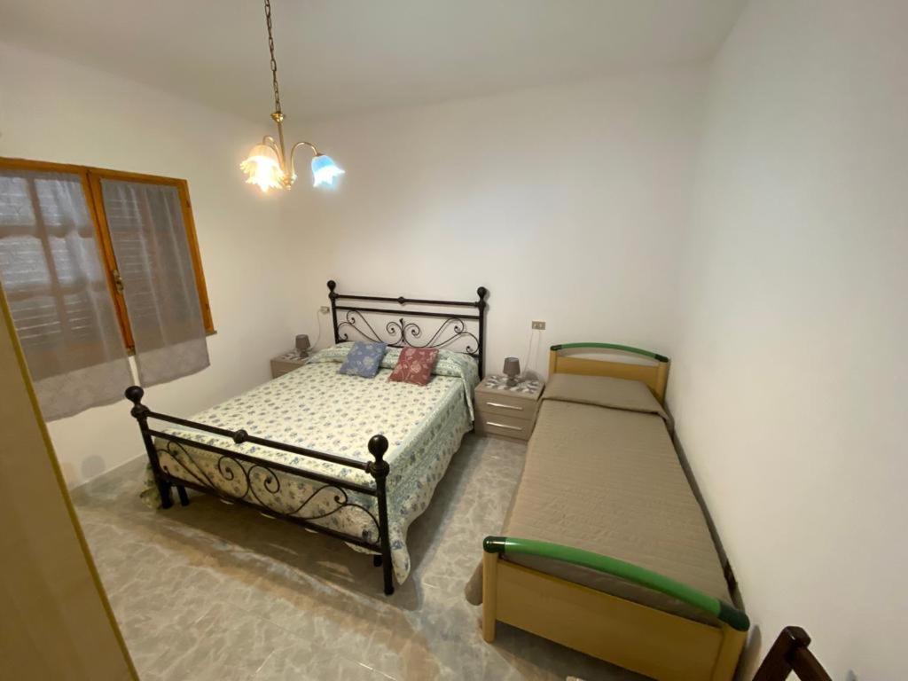 1 Schlafzimmer mit 2 Betten und einem Kronleuchter in der Unterkunft CASA SANT'ANNA in SantʼAnna Arresi