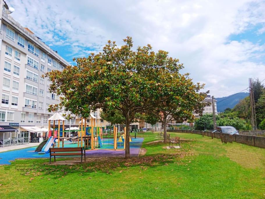 a park with a playground with a tree and a slide at Marusia in Viveiro