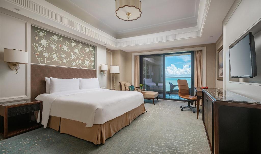a hotel room with a bed and a large window at Grand Hotel Haikou - Managed by Accor in Haikou