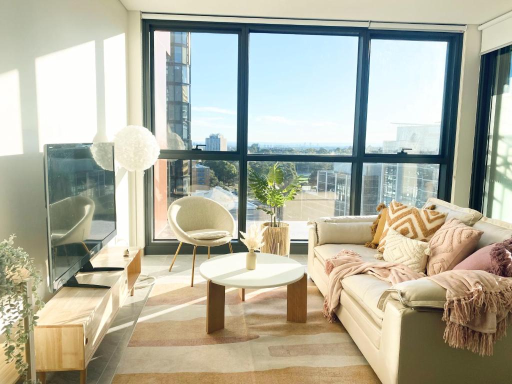 een woonkamer met een bank en een tafel bij Central Apartment St Leonards in Sydney