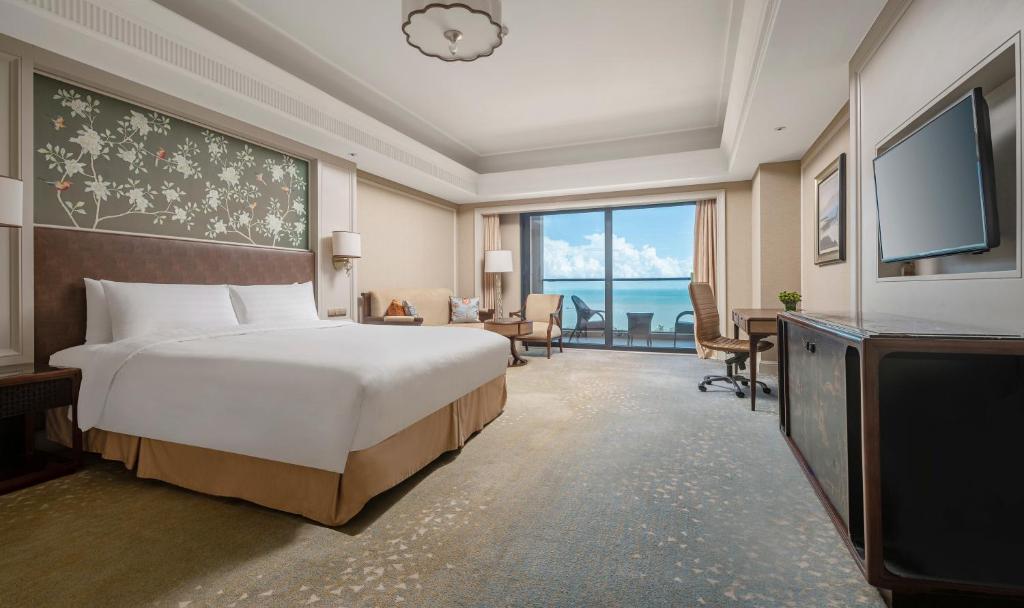 a hotel room with a bed and a television at Grand Hotel Haikou - Managed by Accor in Haikou