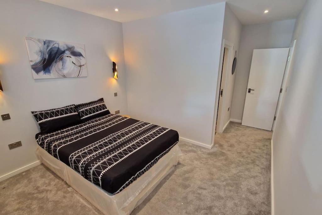 1 dormitorio con 1 cama y una pintura en la pared en Dream apartment Finchley 4 min walk to the train en Hendon