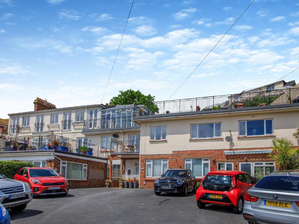 a parking lot with cars parked in front of a building at 7 Roundham Heights in Paignton